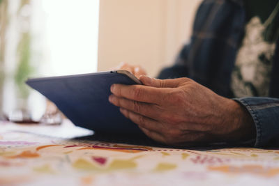 Close-up of man holding hands on table