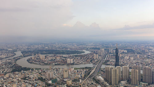 High angle view of city buildings against cloudy sky