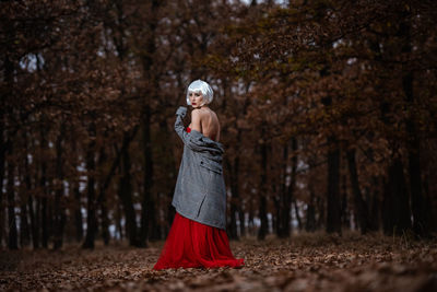 Full length of woman standing in forest