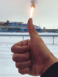 Close-up of person hand against sky