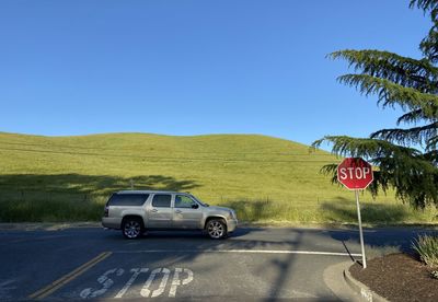 Cars on road against clear blue sky