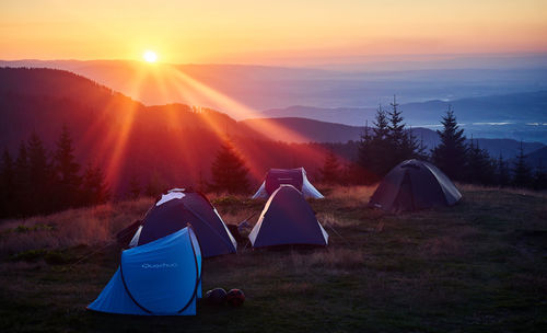 Scenic view of tent against sky during sunset