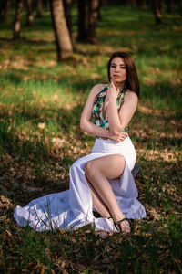 Smiling young woman sitting on field