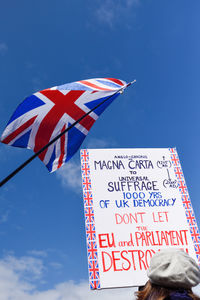 Low angle view of flags against blue sky