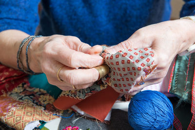 Midsection of woman stitching fabric