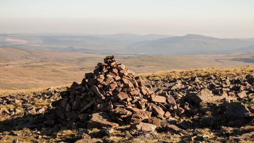 Stack of rock on landscape against sky