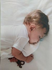 High angle view of cute baby boy sleeping on bed at home