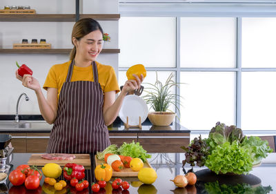 Young woman standing by fruits