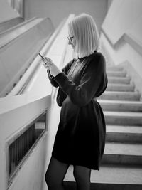 Rear view of woman standing against wall