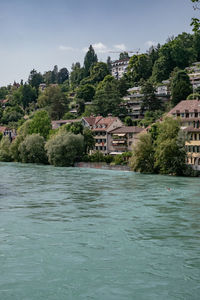 Scenic view of swimming pool by river against buildings