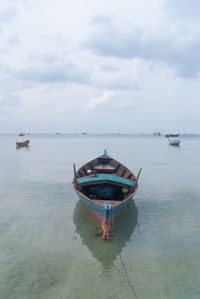 Boat moored on sea against sky