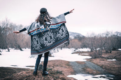 Rear view of person standing on snow covered field