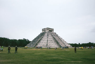 People at historic chichen itza against sky