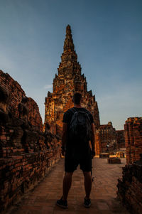 Rear view of man standing against old building