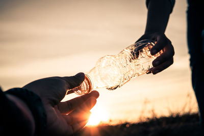 Midsection of people collecting garbage outdoors