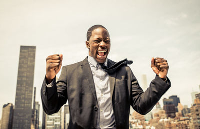 Portrait of man standing against buildings