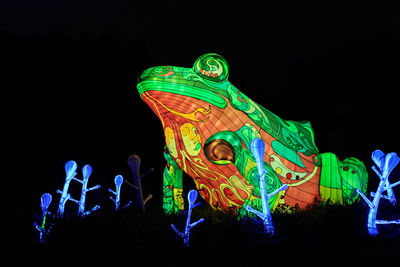 Low angle view of illuminated toys against black background