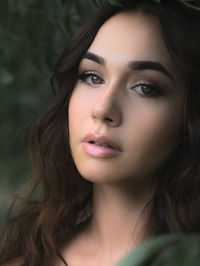 Dreamlike close portrait of a young brunette woman, brown eyes, long hair. light and shadow effect. 