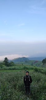 Man standing on field against sky