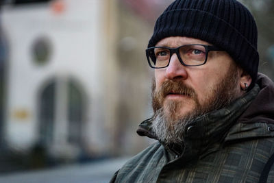 Portrait of man wearing hat in city