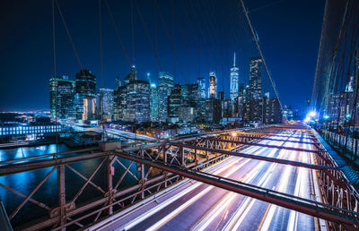 Illuminated bridge and buildings in city at night