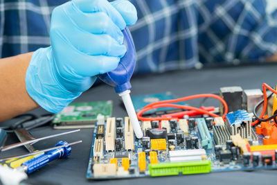 Midsection of engineer repairing mother board