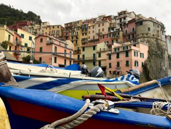 Boats moored at harbor against buildings in city