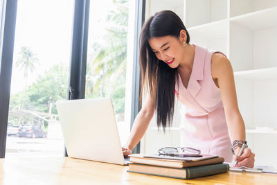 Young woman using phone on table