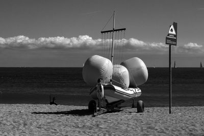 Inflatable raft at beach against sky