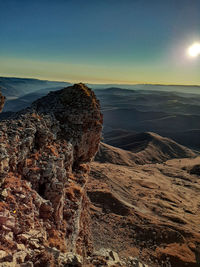 Rock formation on land against sky during sunset