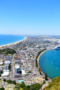 High angle view of sea and buildings against blue sky