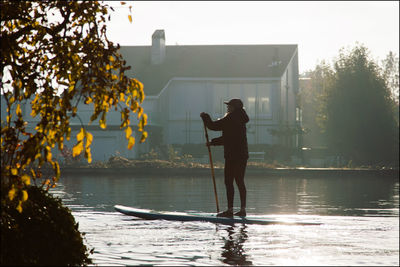 Men standing by lake against trees