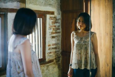 Young woman reflecting on mirror