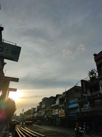 View of city street against sky during sunset