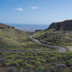 Scenic view of mountains by sea against sky