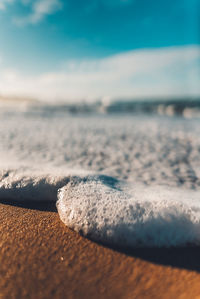 Close-up of pebbles on beach against sky