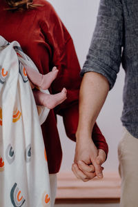 Midsection of couple holding hands