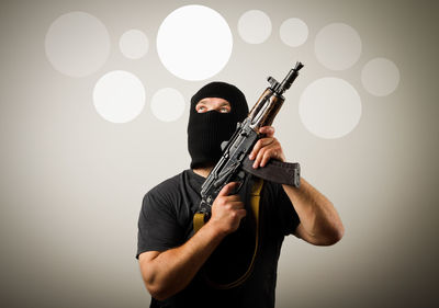 Portrait of man holding guitar against white background