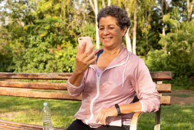 Smiling man sitting on bench at park