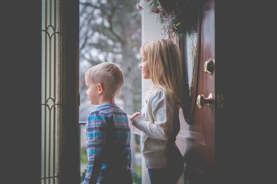 Boy looking through window