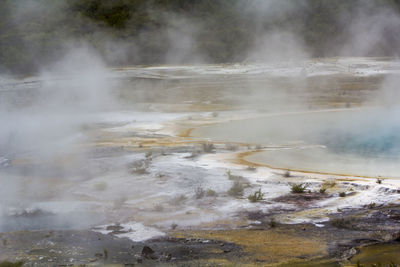 Geothermal activity, rainbow terrace with blue hot spring and steam rising