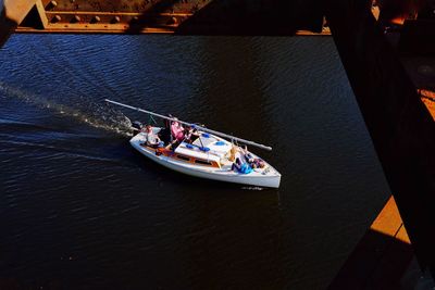 High angle view of people sailing on sailboat on river