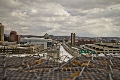 Tilt-shift image of cityscape against cloudy sky
