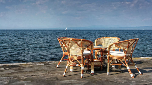 Chairs on beach against sky