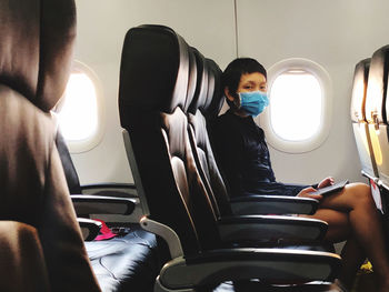 Woman wear surgical mask in airplane to protect virus