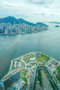 High angle view of city by sea against sky