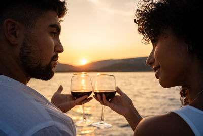 Man drinking beer at sunset