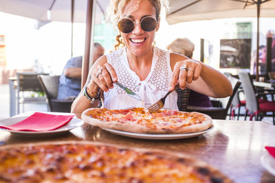 Young woman holding ice cream in restaurant