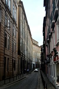 Road amidst buildings in city against sky