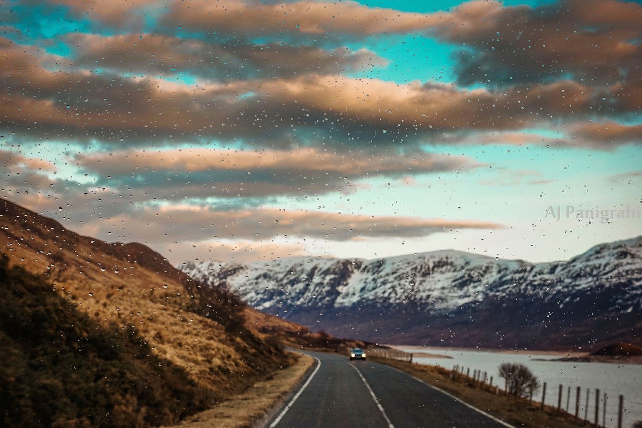 ROAD BY MOUNTAINS AGAINST SKY